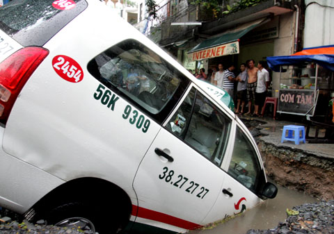 Taxi 7 chỗ lọt xuống “hố địa ngục” ở Sài Gòn